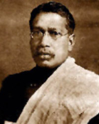 Small sepia-toned photographic portrait of Bipin Chandra Pal, head and shoulders, wearing spectacles and a light shawl over a dark garment.